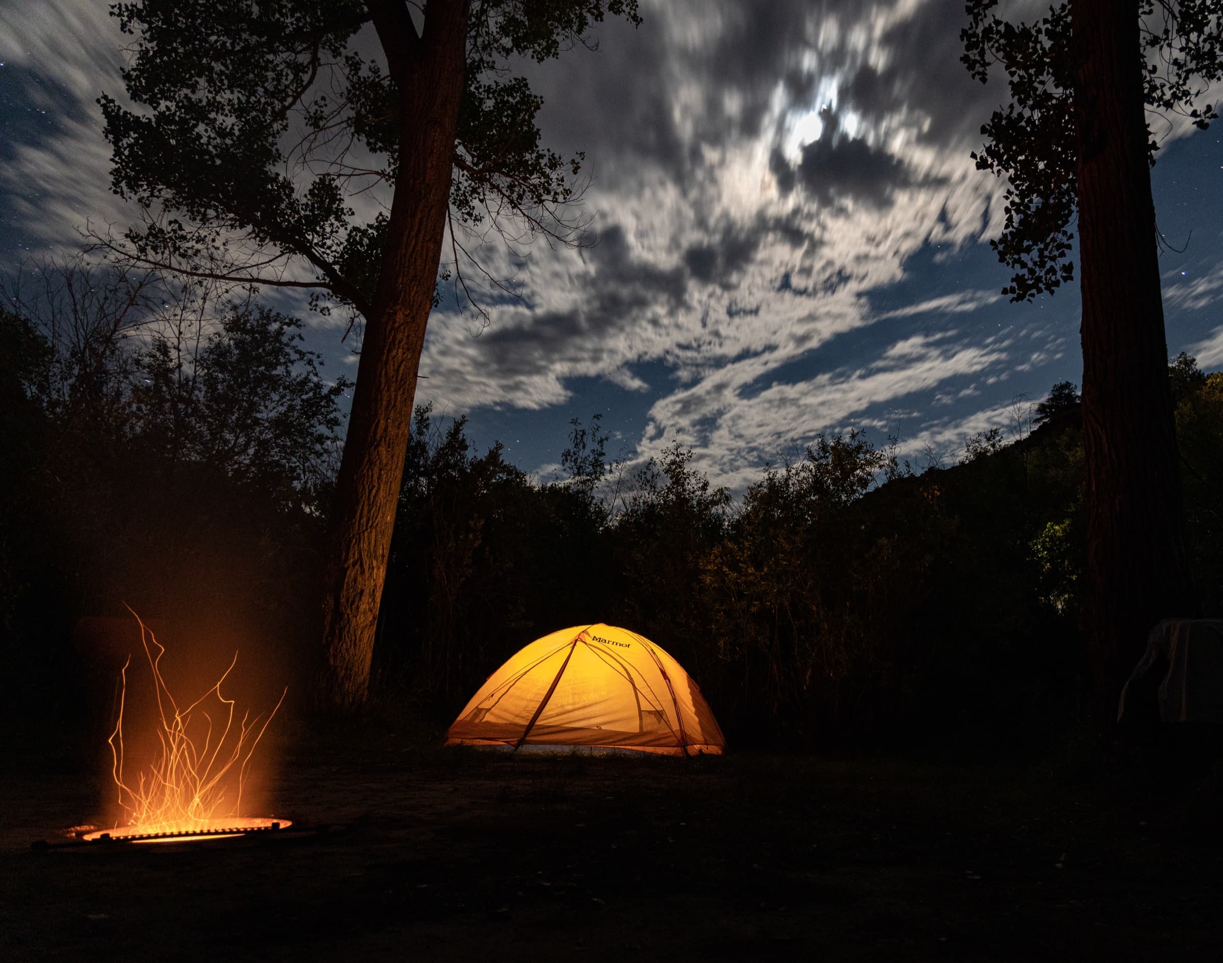 Campfire under moonlit sky